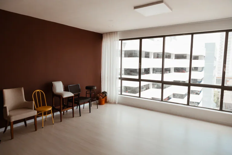 Sala ampla com janelas e cadeiras no Mainelli Estúdio 57